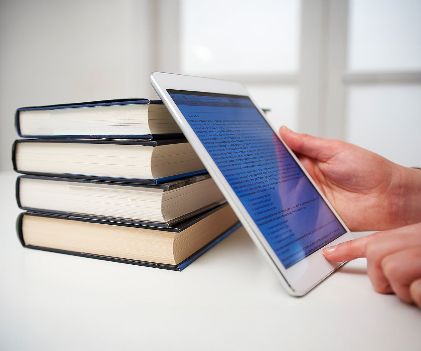 Stacked books and an iPad for resources