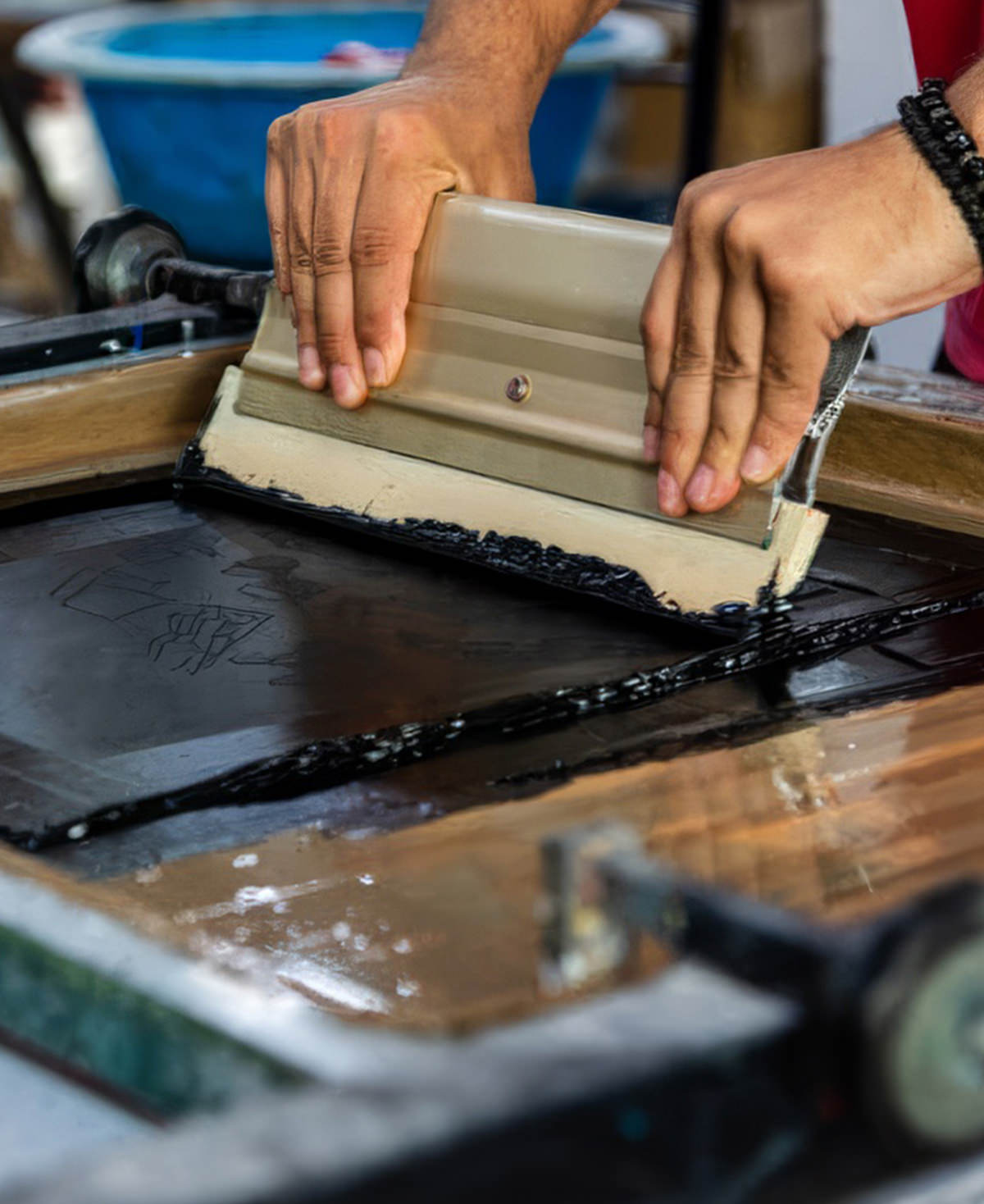 A person screen prints a Fix Studios T-Shirt