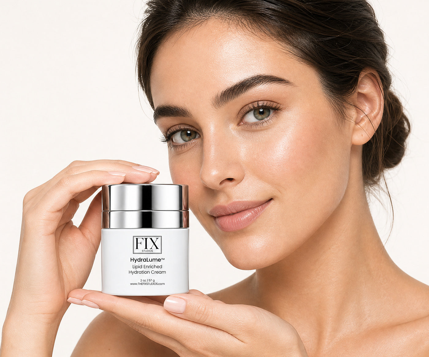 A woman holds a jar of Fix Studios HydraLume™ Lipid Enriched Hydration Cream medical-grade moisturizer