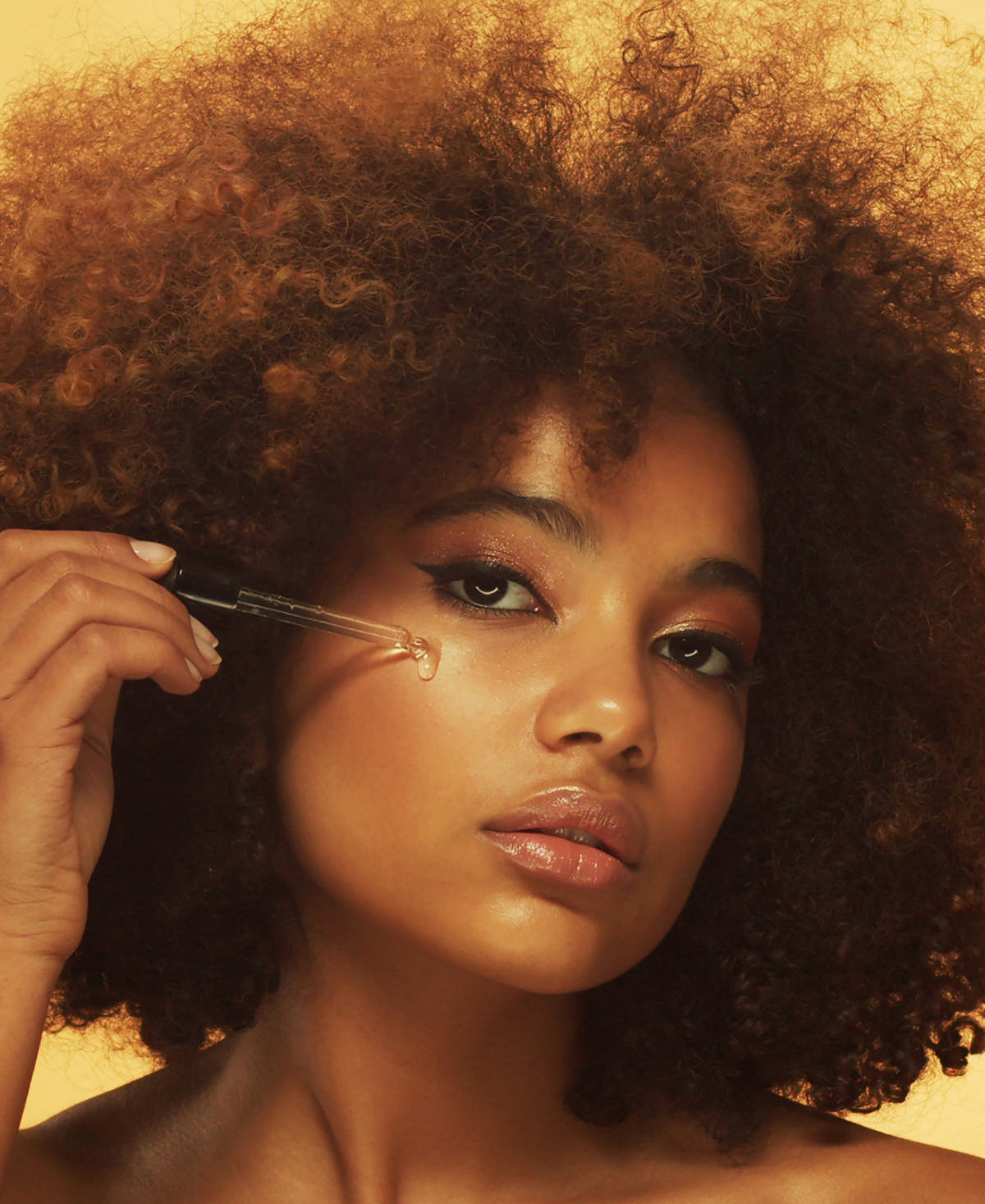 A beautiful woman applies Fix Studios medical-grade LustraCe CE+CTP Antioxidant Radiance Serum packed with 20% vitamin C