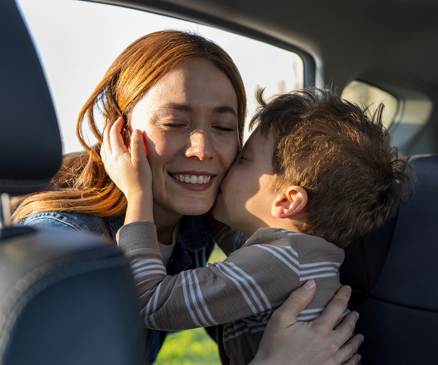 A son kisses his mother on the cheek