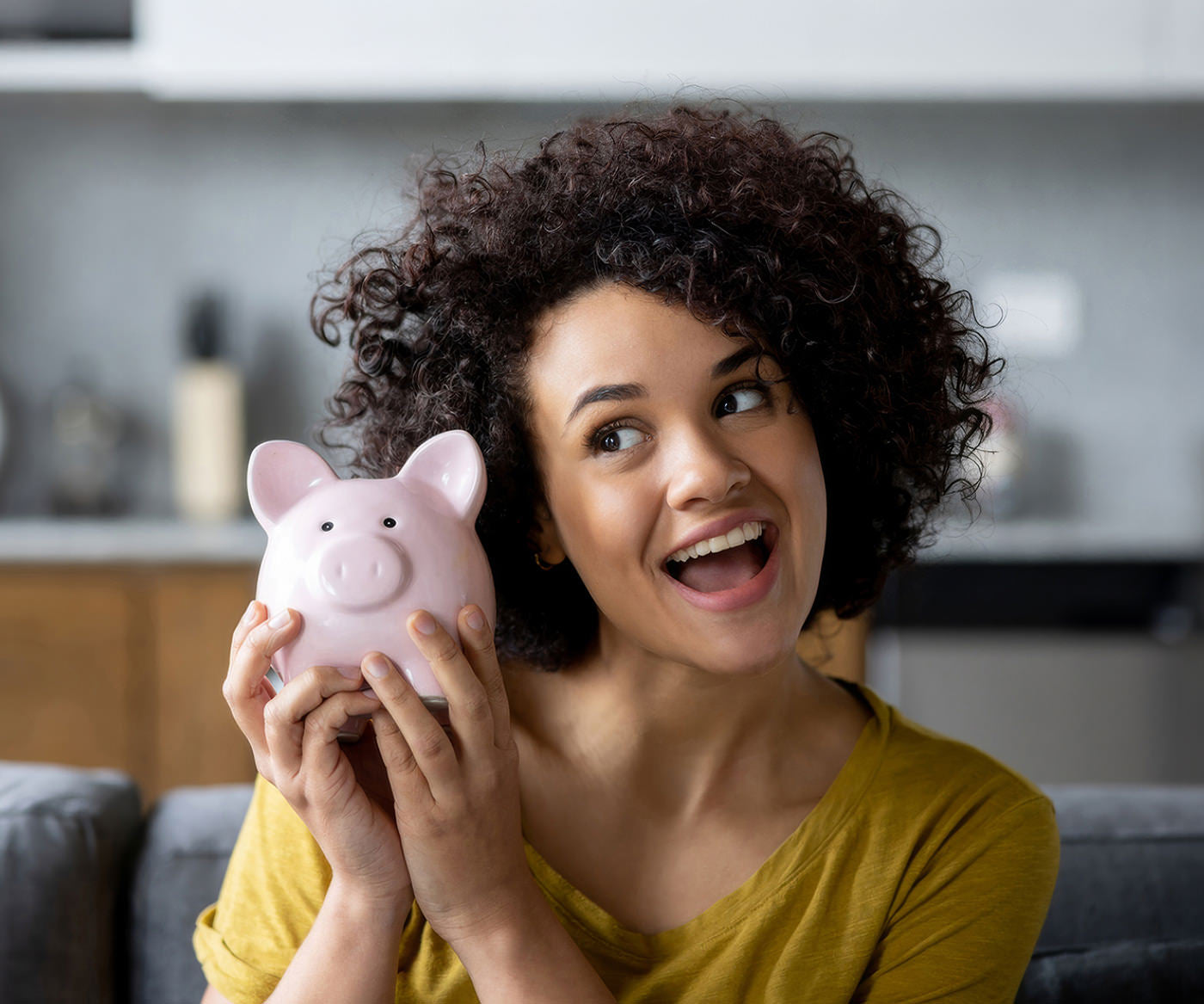 A happy woman holding a piggy bank after saving money with her Fix Studios VIP Membership